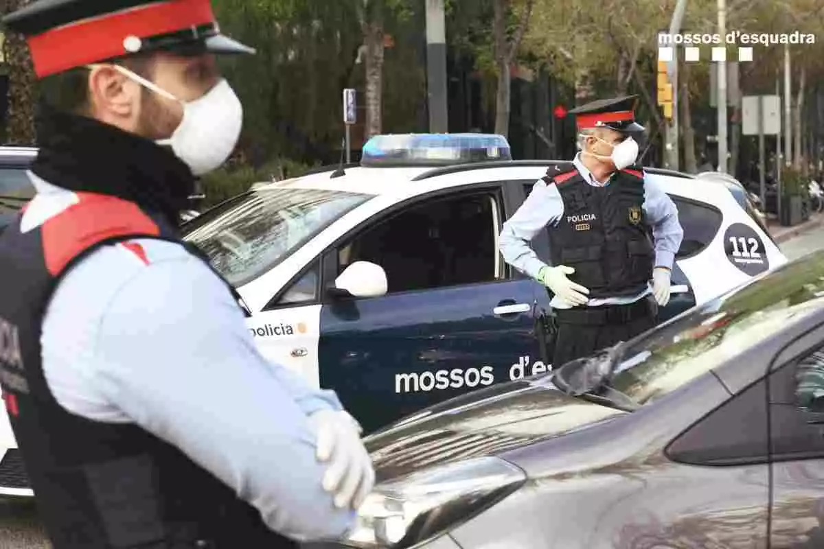 Dos agents dels Mossos d'Esquadra i un cotxe patrulla