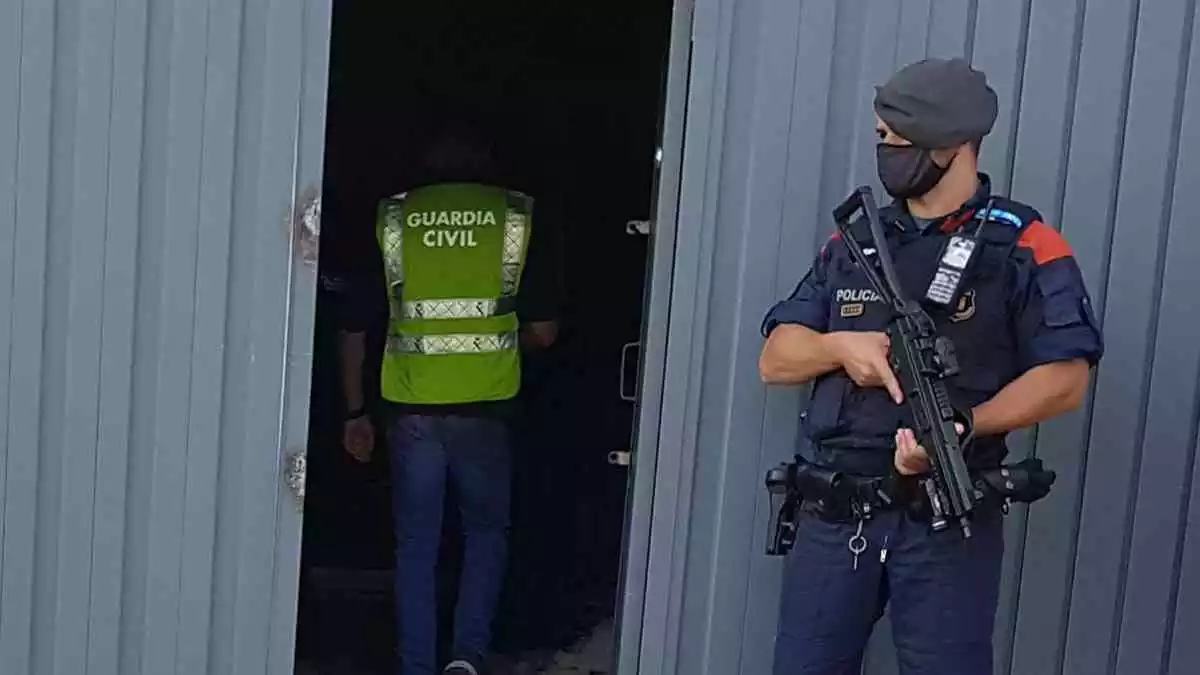 Pla obert d'un agent dels Mossos d'Esquadra i de la Guàrdia Civil a l'entrada de la nau desmantellada