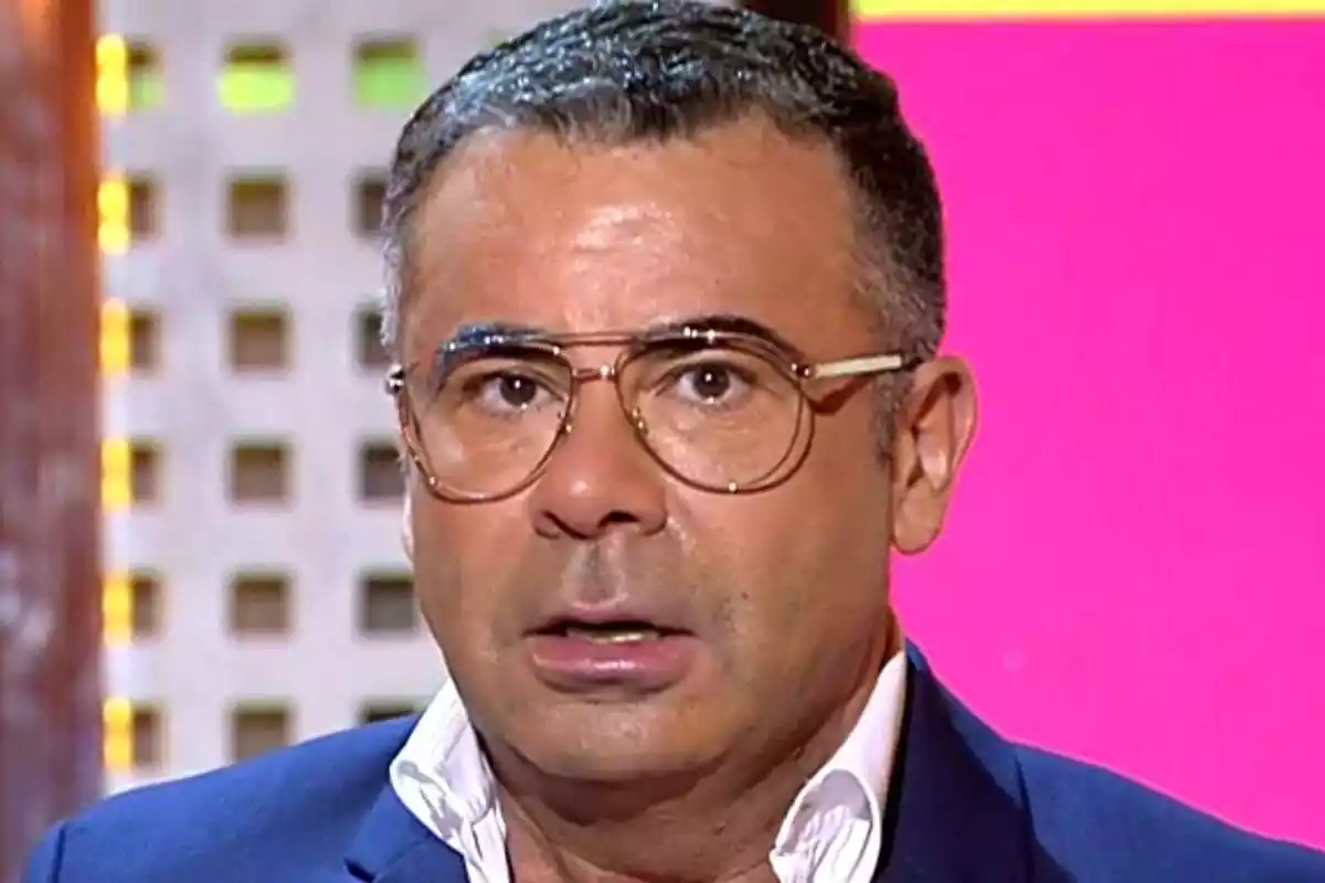 Hombre con gafas y expresión sorprendida en un set de televisión.